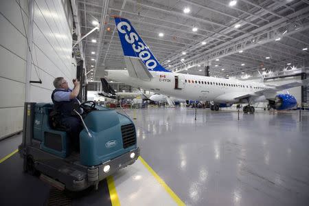 A Bombardier Inc worker takes a photo of the CS300 Aircraft prior to its' test flight in Mirabel February 27, 2015. REUTERS/Christinne Muschi