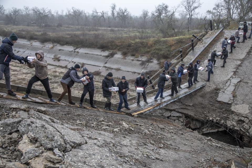 <div class="inline-image__caption"><p>Locals help transferring humanitarian aid across a collapsed bridge near Novopetrivka, following the withdrawal of Russian troops from Kherson region, Ukraine, Nov. 17, 2022.</p></div> <div class="inline-image__credit">Narciso Contreras/Anadolu Agency via Getty Images</div>