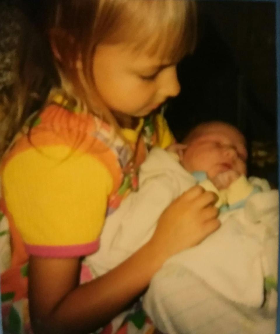 The author, age 5, holding baby No. 6, Micah, after a home birth in Kent, Minnesota, in 1997