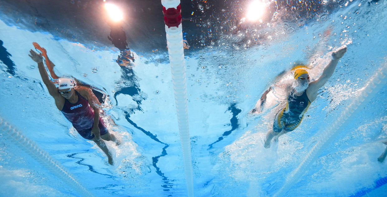 Seen from below, in the pool, Mollie O'Callaghan, right, of Australia, and Barbora Seemanova, of the Czech Republic, compete in the women's 200-meter freestyle in Nanterre, France. 