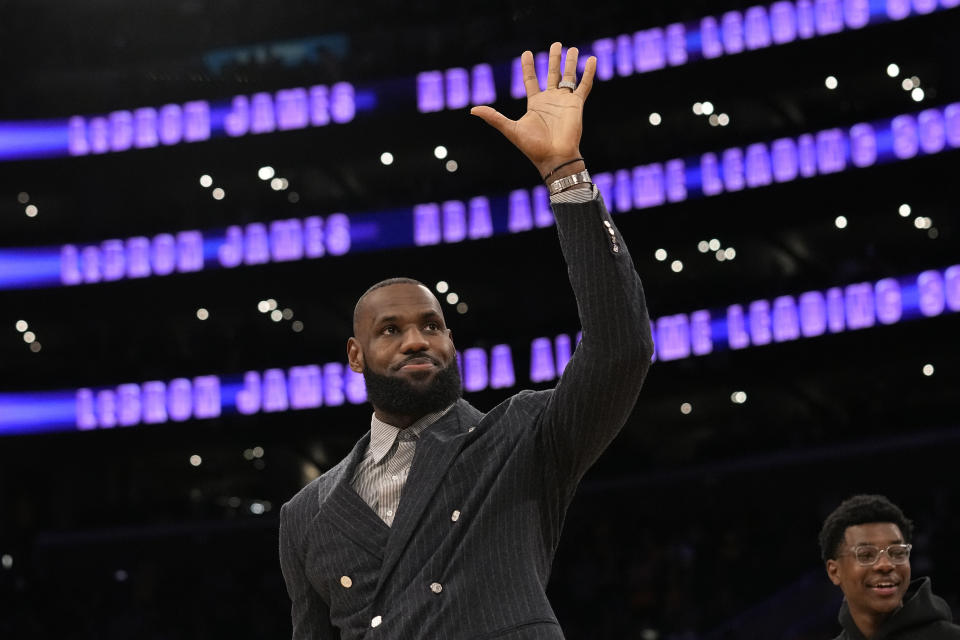 Los Angeles Lakers forward LeBron James waves to fans during a ceremony honoring him as the NBA's all-time leading scorer before an NBA game against the Milwaukee Bucks on Thursday, Feb. 9, 2023, in Los Angeles. James passed Kareem Abdul-Jabbar to earn the record during Tuesday's NBA game against the Oklahoma City Thunder. (AP Photo/Mark J. Terrill)