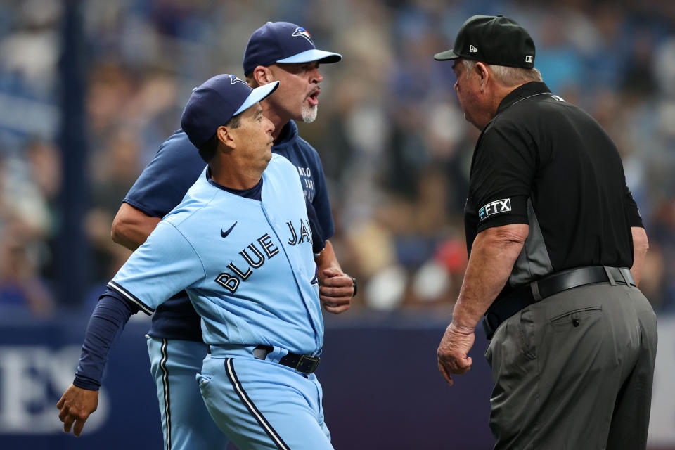 El mánager Charlie Montoyo #25 de los Azulejos de Toronto detiene al entrenador de lanzamiento Pete Walker #40 mientras habla con el árbitro Joe West #22 durante el juego con los Tampa Bay Rays. (Foto:  Mike Carlson/MLB Photos a través de Getty Images)