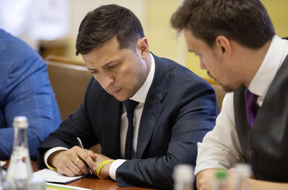 Ukrainian President Volodymyr Zelenskiy, left, attends a cabinet meeting in Kiev, Ukraine, Friday, July 19, 2019.Ukraine's president on Friday outlined the details of an impending prisoner swap with Russia, saying that Kiev is willing to release a jailed Russian journalist in exchange for a Ukrainian film director. (Ukrainian Presidential Press Office via AP)