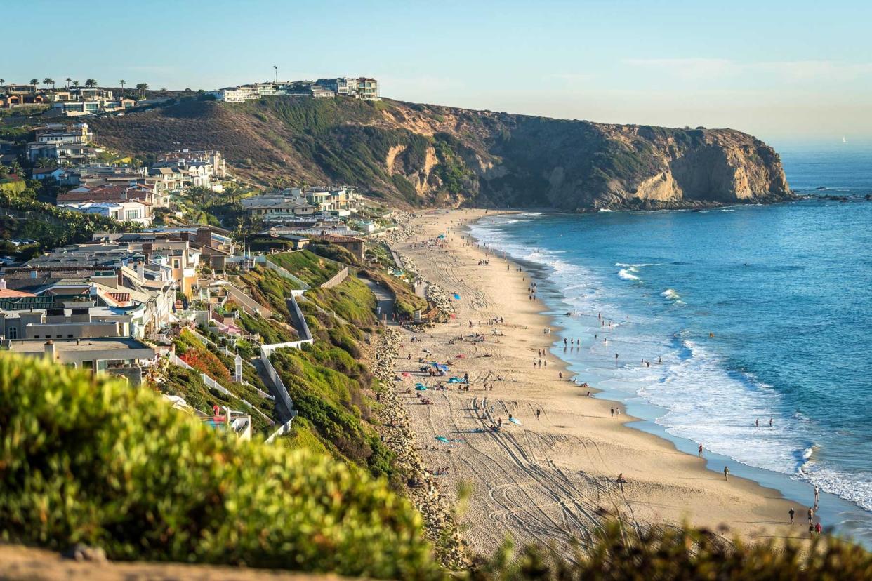 Homes overlooking the ocean and beach with surfers in Orange County, California near Dana Point