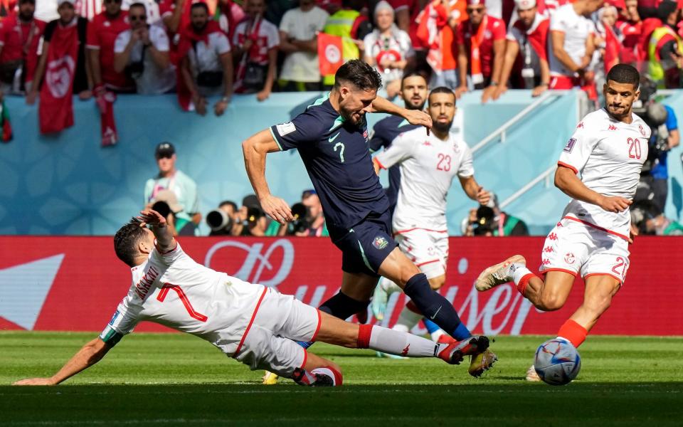 Tunisia's Youssef Msakni, left, and Australia's Mathew Leckie, center, challenge for the ball during the World Cup group D soccer match between Tunisia and Australia at the Al Janoub Stadium in Al Wakrah, Qatar, Saturday, Nov. 26, 2022 - AP Photo/Luca Bruno