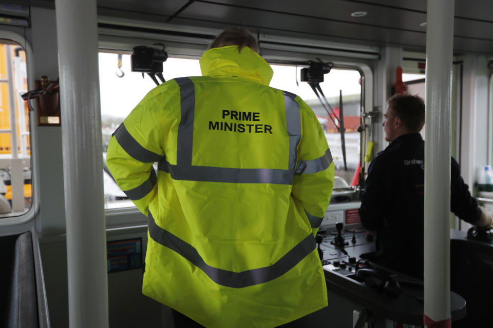 Britain's Prime Minister Boris Johnson wears safety clothing reading "Prime Minister" during a General Election campaign stop aboard a tog boat in the port of Bristol, England, Thursday, Nov. 14, 2019. Britain goes to the polls on Dec. 12. (AP Photo/Frank Augstein, Pool)