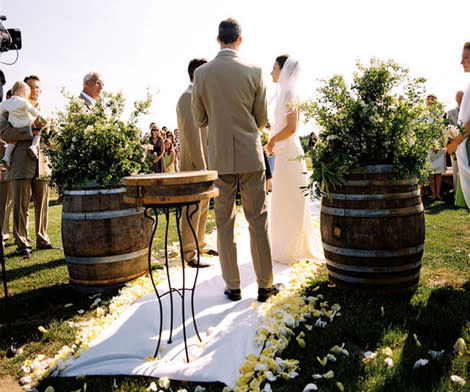 A couple exchanges vows, framed by barrels of lush wildflowers.