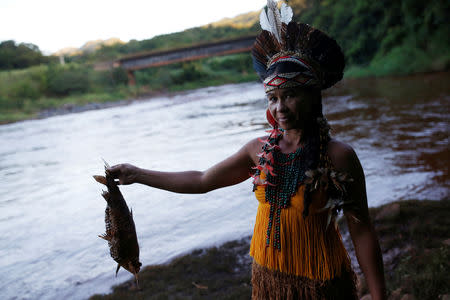 An Indigenous woman from the Pataxo Ha-ha-hae tribe holds up a dead fish near Paraopeba river, after a tailings dam owned by Brazilian mining company Vale SA collapsed, in Sao Joaquim de Bicas near Brumadinho, Brazil January 28, 2019. REUTERS/Adriano Machado