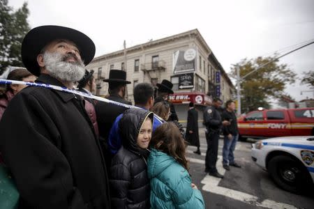 Residents gather behind a cordon near the site of an apparent gas explosion and fire in the Brooklyn borough of New York October 3, 2015. REUTERS/Carlo Allegri