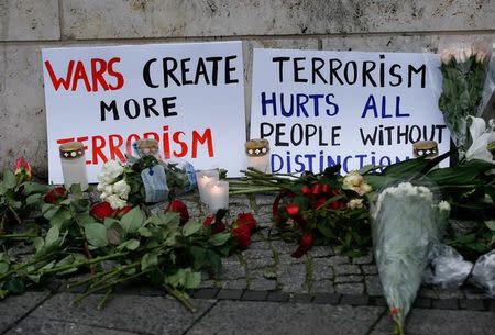 Flowers and posters are placed at the scene where a truck ploughed into a crowded Christmas market in the German capital last night in Berlin, Germany, December 20, 2016 REUTERS/Fabrizio Bensch