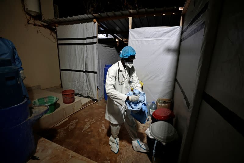 Professor Moussa Seydi, removes his personal protective equipment (PPE) after meeting his patients suffering from the coronavirus disease (COVID-19) at the infectious diseases department of the the University Hospital Fann, in Dakar