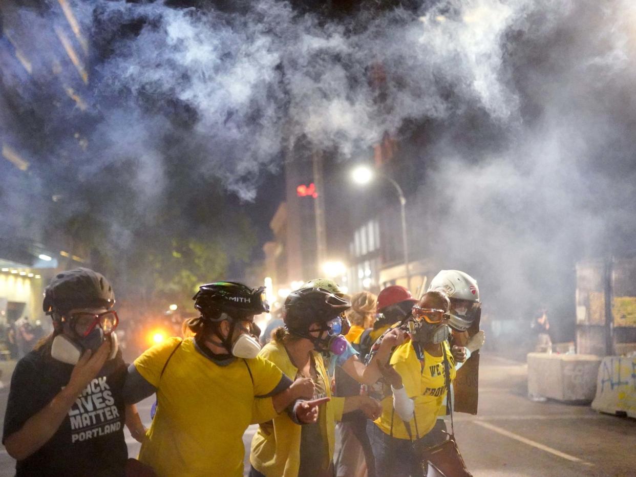 Members of Moms United for Black Lives Matter brace themselves against tear gas fired by federal officers in Portland, Oregon: Getty Images