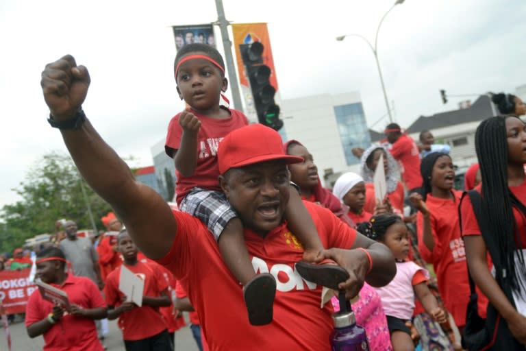 A man chants carrying his child on his shoulders during a rally to mark 500 days since the abductions of the Chibok schoolgirls by Boko Haram militants, in Abuja on August 27, 2015