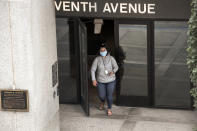 A woman wearing a face mask exits the Atwood Building, a downtown Anchorage, Alaska, building where many state offices are located on Monday, June 29, 2020. The Municipality of Anchorage on Monday instituted a requirement that most people should wear masks in indoor public settings, but Attorney General Kevin Clarkson sent an email to state employees saying that state buildings within the municipality were exempt from that order. (AP Photo/Mark Thiessen)