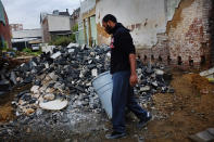 READING, PA - OCTOBER 20: A man clears debris from a demolished home on October 20, 2011 in Reading, Pennsylvania. Reading, a city that once boasted numerous industries and the nation's largest railroad company, has recently been named America's poorest city with residents over 65,000. According to new census data, 41.3 percent of people live below the poverty line in Reading. Reading has about 90,000 residents, many of whom are recent Hispanic arrivals who have moved from larger eastern cities over the past decade. While a manufacturing base offering well paying jobs still exists in Reading, many companies like Hershey, Stanley Tool and Dana Systems have either moved elsewhere in the United States or to Mexico in search of cheaper labor. The number of people living in poverty in America, 46.2 million, is now at its highest level for the 52 years the Census Bureau has been keeping records. (Photo by Spencer Platt/Getty Images)