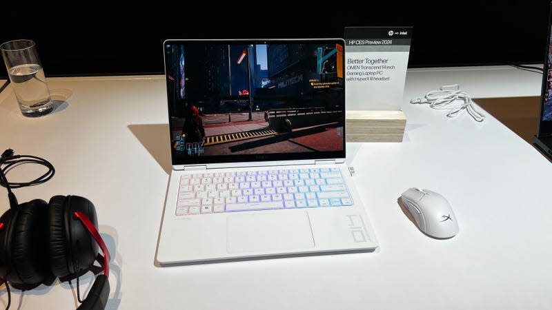 A White HP Omen 14 with its rainbow LED keys in white next to an Omen mouse and headset.