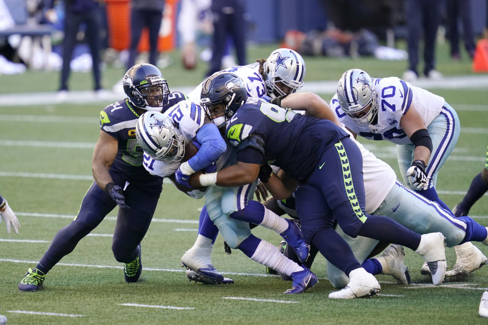 Seattle Seahawks middle linebacker Bobby Wagner, left, and defensive tackle Bryan Mone (92) tackle Dallas Cowboys running back Ezekiel Elliott (21) during the second half of an NFL football game, Sunday, Sept. 27, 2020, in Seattle. The Seahawks won 38-31. (AP Photo/Elaine Thompson)