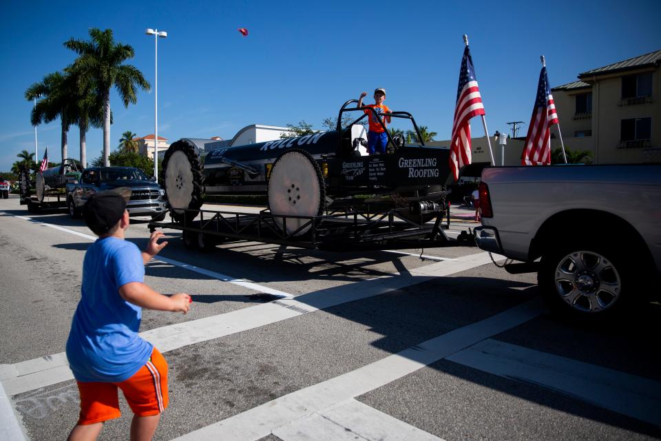 Bentley Mosser, 9, left, catches candy thrown from "Roll On" during the Swamp Buggy Parade on US 41 in Naples on Saturday, November 2, 2019. 