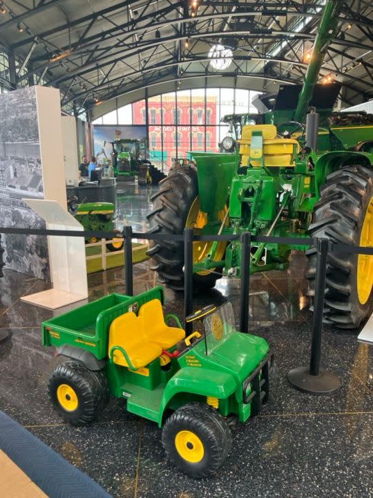 A 2001 electric-powered toy Gator, seen in front of the pavilion’s 1960 John Deere 4010 tractor.
