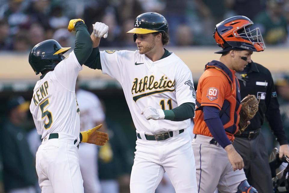 Oakland Athletics' Skye Bolt, center, celebrates after hitting a two-run home run that also scored Tony Kemp, left, as Houston Astros catcher Korey Lee, front right, looks on during the fourth inning of a baseball game in Oakland, Calif., Monday, July 25, 2022. (AP Photo/Jeff Chiu)