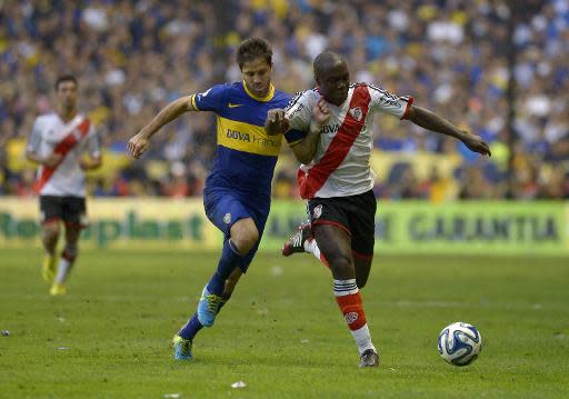 El defensa colombiano de River Plate Éder Álvarez Balanta (D) pugna por un balón ante Juan Martínez, de Boca Juniors, en el clásico del fútbol argentino disputado en La Bombonera de Buenos Aires, el 30 de marzo de 2014 (AFP/Archivos | JUAN MABROMATA)