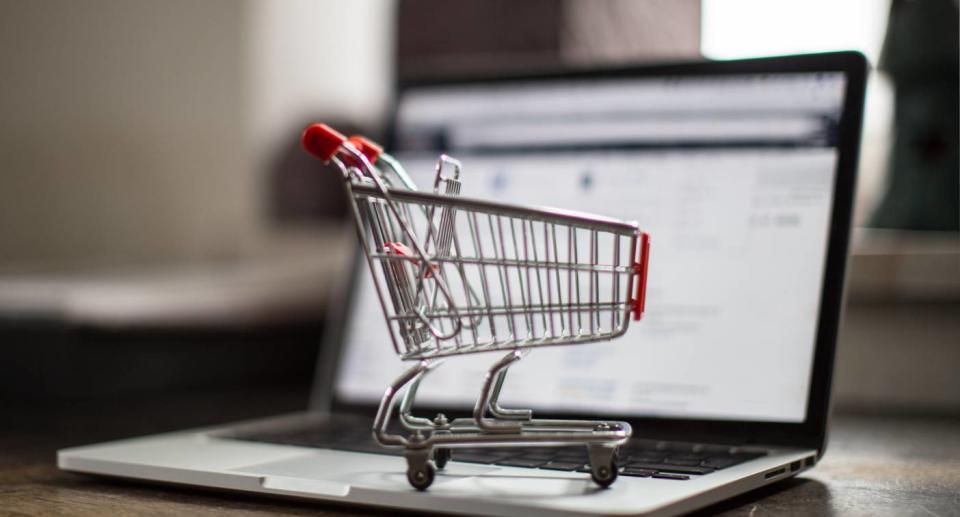 Model shopping trolley sitting on laptop computer