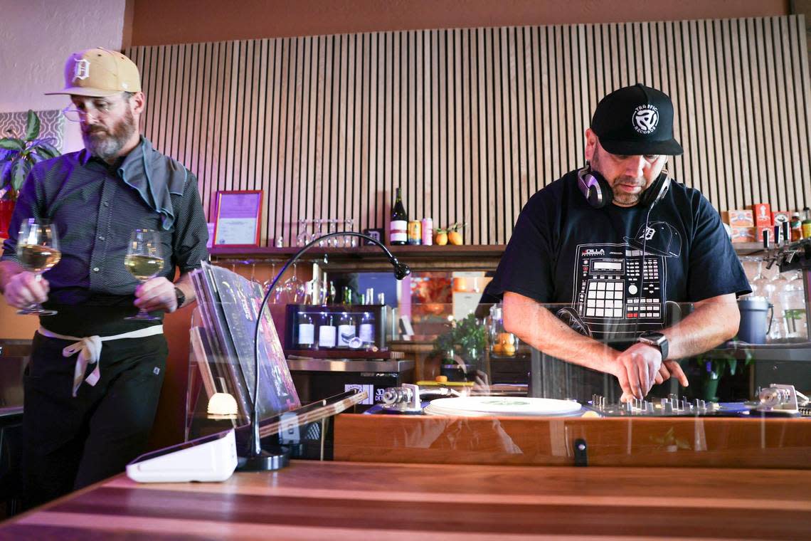 Jeff Root, co-owner of Jan’s Place in San Luis Obispo, serves wine as guest DJ Jason Perez spins vinyl during a special event on March 13, 2024.
