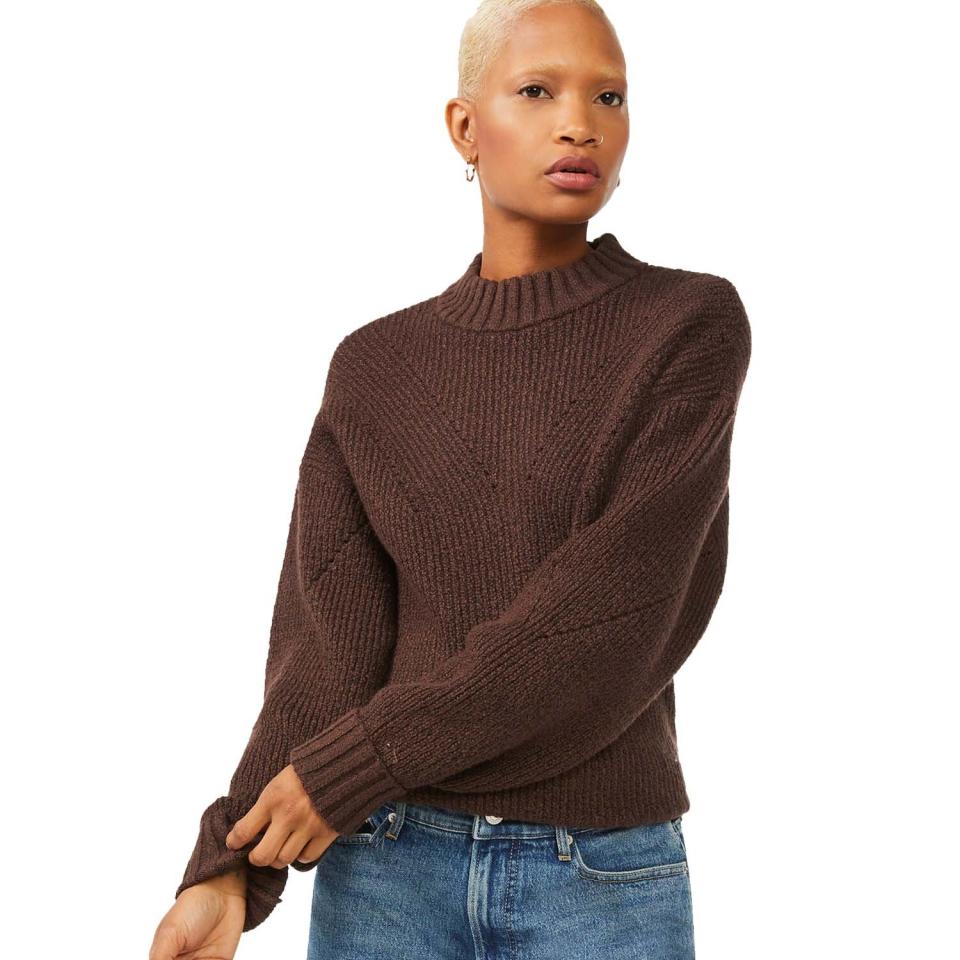 woman wearing brown sweater and blue jeans