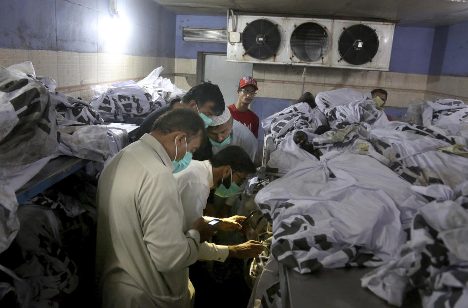 People identify body of their relative, who was killed in the Friday's plane crash, at a morgue in Karachi, Pakistan, Saturday, May 23, 2020. An aviation official says a passenger plane belonging to state-run Pakistan International Airlines carrying passengers and crew has crashed near the southern port city of Karachi. (AP Photo/Fareed Khan)