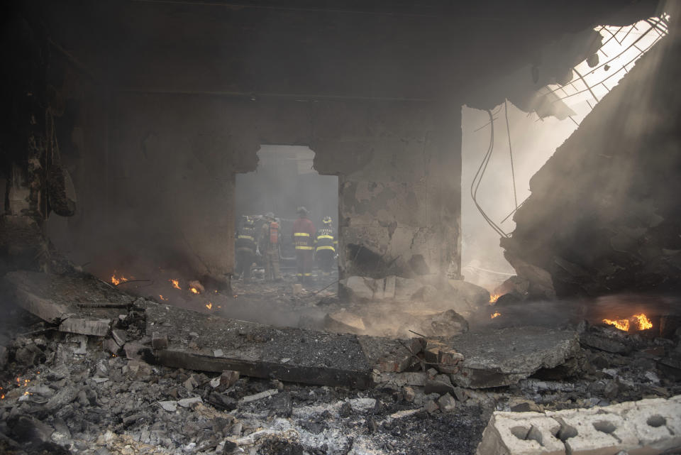 Firefighters put out a fire after a powerful explosion in San Cristobal, Dominican Republic, Monday, Aug 14, 2023. The Monday afternoon explosion killed at least three people and injured more than 30 others, authorities said. (Jolivel Brito/Diario Libre via AP)