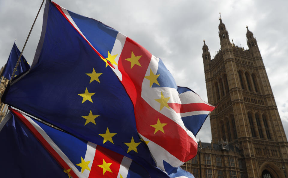 Anti Brexit protesters hold onto their flags and placards as they demonstrate outside the Houses of Parliament in London, Tuesday, March 26, 2019. British Prime Minister Theresa May's government says Parliament's decision to take control of the stalled process of leaving the European Union underscores the need for lawmakers to approve her twice-defeated deal. (AP Photo/Alastair Grant)