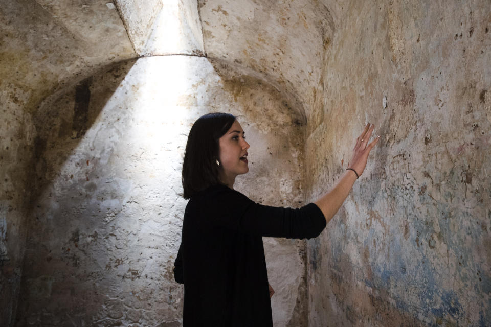 Manager of historic preservation Liz Trumbull discusses the dozens of layers of highly decorated paint on the walls of a cell, Thursday, May 2, 2019, found during the process of making a recreation of mobster Al Capone's 1929 cell at the Eastern State Penitentiary, which is now a museum in Philadelphia. (AP Photo/Matt Rourke)