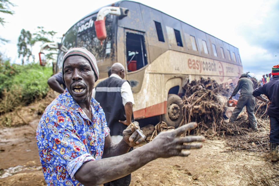 People try to clear a bus that was washed away after a dam burst in Kamuchiri Village Mai Mahiu, Nakuru County, Kenya, Monday, April. 29, 2024. Kenya's Interior Ministry says at least 45 people have died and dozens are missing after a dam collapsed following heavy rains. (AP Photo/Patrick Ngugi)