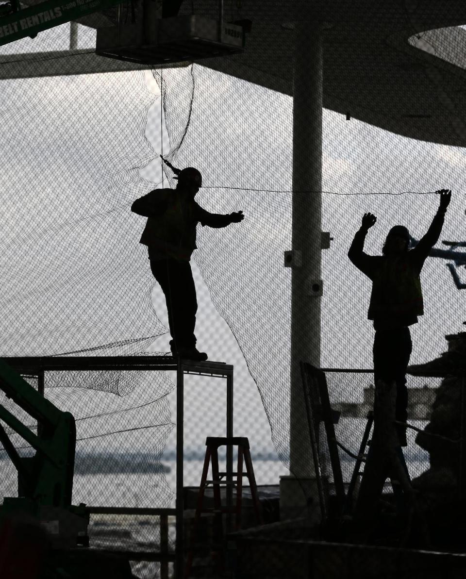 In this Thursday, Dec. 8, 2016 photo, workers set up netting during construction at the Patricia and Phillip Frost Museum of Science in Miami. Rising next to Miami's spiffy new bayside art museum is a $305 million science museum that, like South Florida, is focused in large part on water: its centerpiece is a 500,000-gallon aquarium that will feature sharks, tuna, mahi-mahi and even sea turtles, with other smaller tanks for corals and other sea life. The Frost Science Museum, scheduled to open this spring. (AP Photo/Wilfredo Lee)