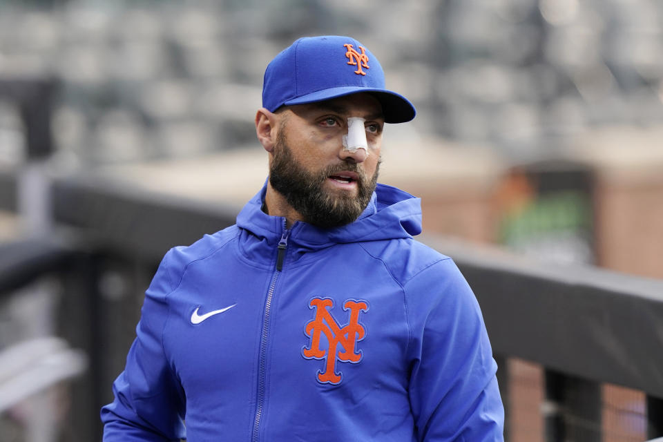 Injured New York Mets player Kevin Pillar wears a bandage on his nose in the dugout before a baseball game against the Colorado Rockies, Monday, May 24, 2021, in New York. Pillar was hit in the face by a fastball last week and underwent surgery Friday to repair nasal fractures. (AP Photo/Kathy Willens)