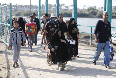 Displaced Sunni people fleeing the violence in Ramadi, cross a bridge on the outskirts of Baghdad, November 10, 2015. REUTERS/Thaier Al-Sudani