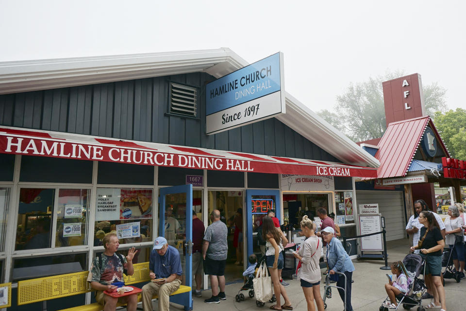 A line for breakfast runs down the block outside the popular Hamline Church Dining Hall on the opening day of the Minnesota State Fair in Falcon Heights, Minn., on Thursday, Aug. 24, 2023. Dozens of church dining halls like this Methodist one once operated at the fair, but only two remain, providing pastors opportunities for both fundraising and showcasing faith-based hospitality. (AP Photo/Giovanna Dell'Orto)