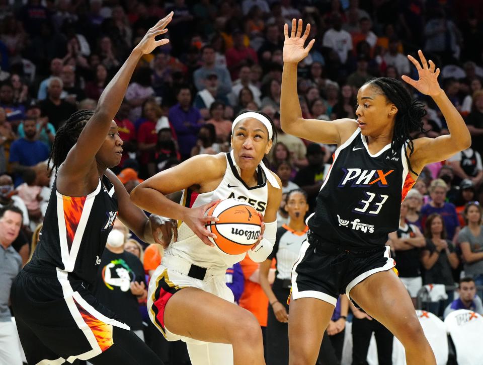 Aces' A'ja Wilson (22) spins in the post against Mercury's Tina Charles (L) and Kristine Anigwe (33) during the home opener.