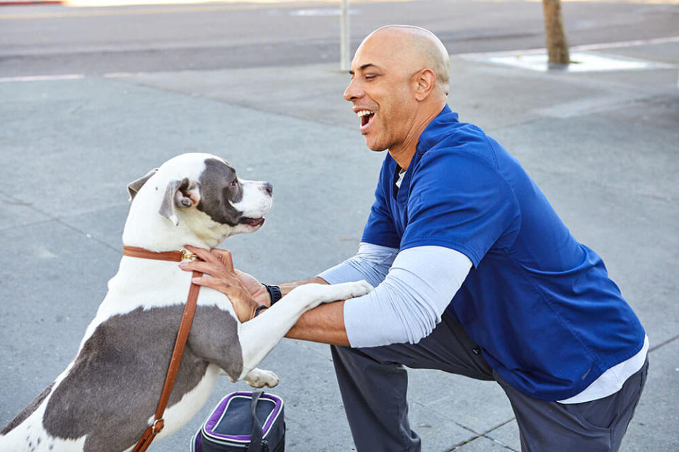 Dr. Kwane Stewart smiles with a dog. (GoFundMe Heroes)