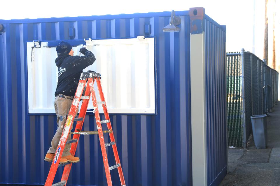 A painter puts finishing touches on a kiosk at Heritage Financial Park on March 21, 2023. 