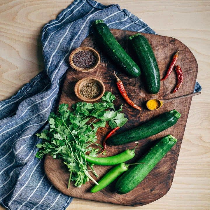 zucchini, peppers, and herbs on a cutting board