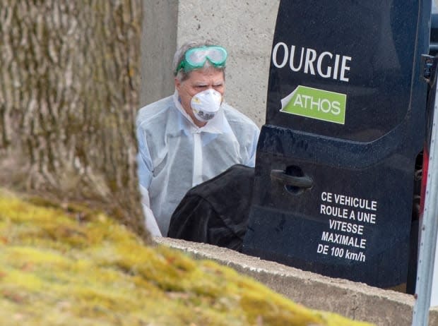 A funeral home worker removes a body from the CHSLD Sainte-Dorothée in Laval in April 2020. More than 100 residents died of COVID-19 at the home. (Ryan Remiorz/The Canadian Press - image credit)