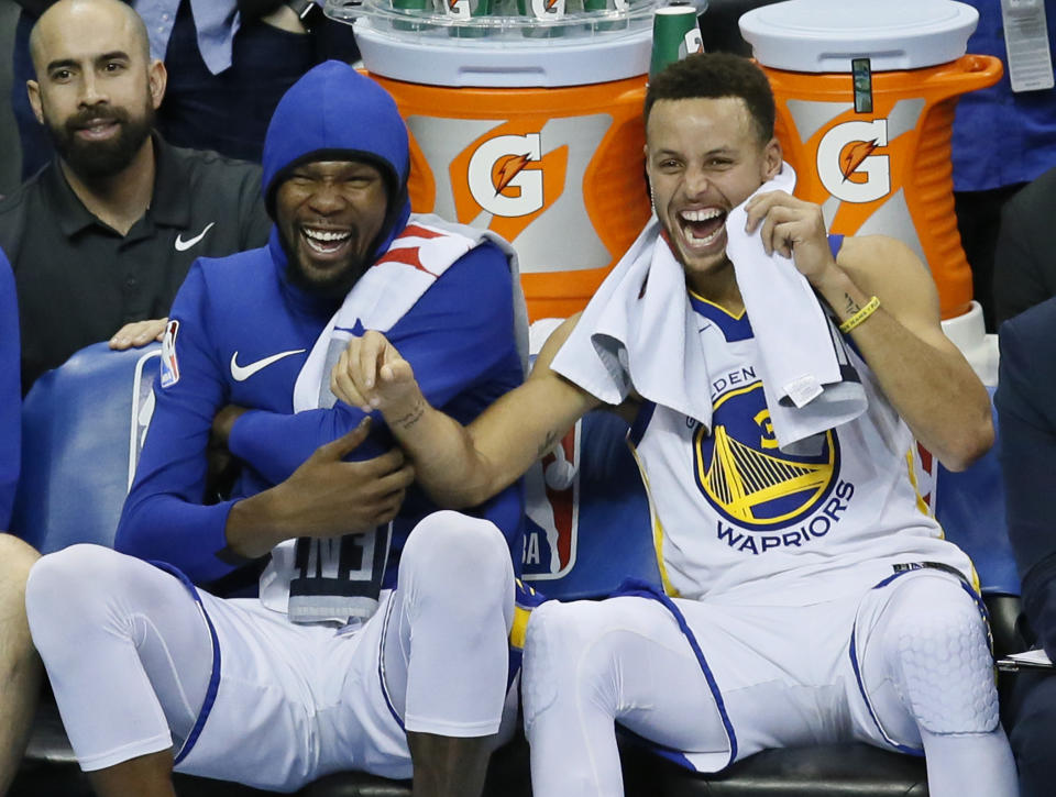 FILE - In this Nov. 22, 2017, file photo, Golden State Warriors forward Kevin Durant, left, and guard Stephen Curry, right, laugh on the bench during the third quarter of the team's NBA basketball against the Oklahoma City Thunder in Oklahoma City. Someday, years or even decades from now, at one of those celebratory reunions teams like to do, Stephen Curry knows he and Kevin Durant will reminisce with fondness about their three insanely successful years together on the Golden State Warriors. They will reflect on the greatness, the fun, all they learned from each other shooting side by side day after day to become better from their time as teammates. Two championships, a pair of NBA Finals MVP awards for Durant. (AP Photo/Sue Ogrocki, File)