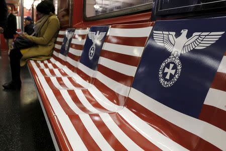 Passengers ride a 42nd Street Shuttle subway train, wrapped with advertising for the Amazon series "The Man in the High Castle", in the Manhattan borough of New York, November 24, 2015. REUTERS/Brendan McDermid