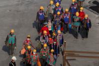 Workers leave a construction site at the end of their shift in the Central Business District in Beijing