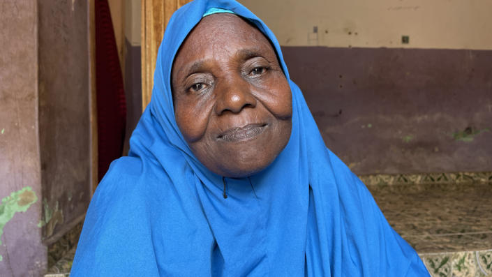 A woman in a blue headscarf looking at the camera