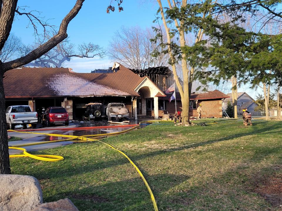 Firefighters fight a blaze in a home at 9855 N.E. Frisk Drive in Ankeny on Saturday. Deputy Fire Chief Dan Schellhase said the fire started in the pickup truck parked on the right side of the driveway. Also damaged was the 1930 Ford Model A parked next to it.