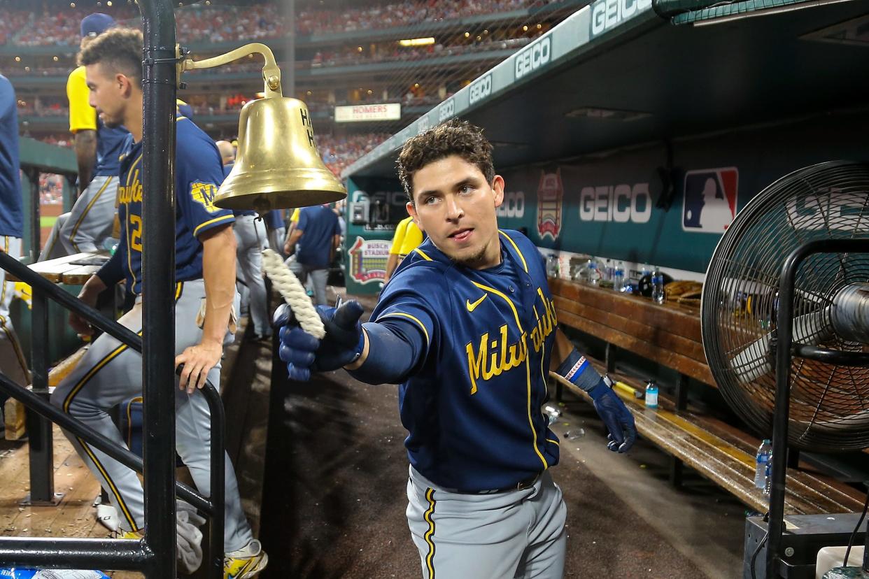 Luis Urías rings the bell in the Brewers dugout after socking a solo home run against the Cardinals in the eighth inning Saturday night in an eventual 3-2 Milwaukee win in 10 innings.