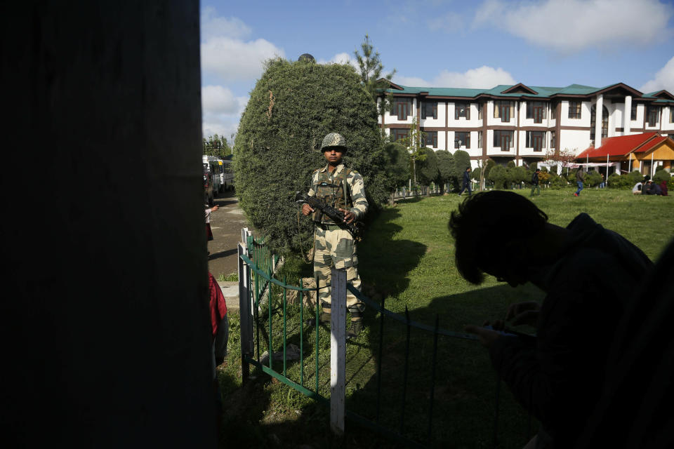 An Indian soldier stands guard outside a poling station during the second phase of India's general elections, on the outskirts of Srinagar, Indian controlled Kashmir, Thursday, April 18, 2019. Kashmiri separatist leaders who challenge India's sovereignty over the disputed region have called for a boycott of the vote. Most polling stations in Srinagar and Budgam areas of Kashmir looked deserted in the morning with more armed police, paramilitary soldiers and election staff present than voters. (AP Photo/Mukhtar Khan)