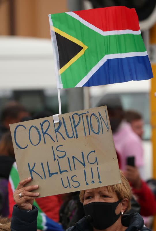 FILE PHOTO: A protestor waves a placard during a march against corruption in Cape Town